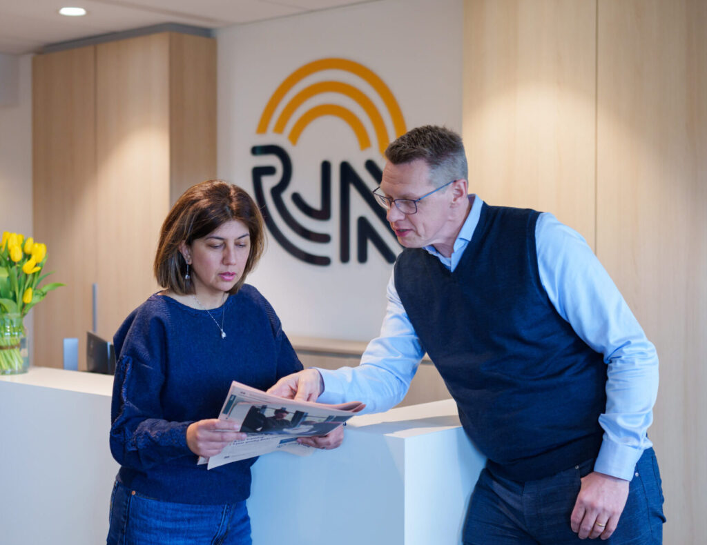 Man en vrouw staan en lezen de krant
